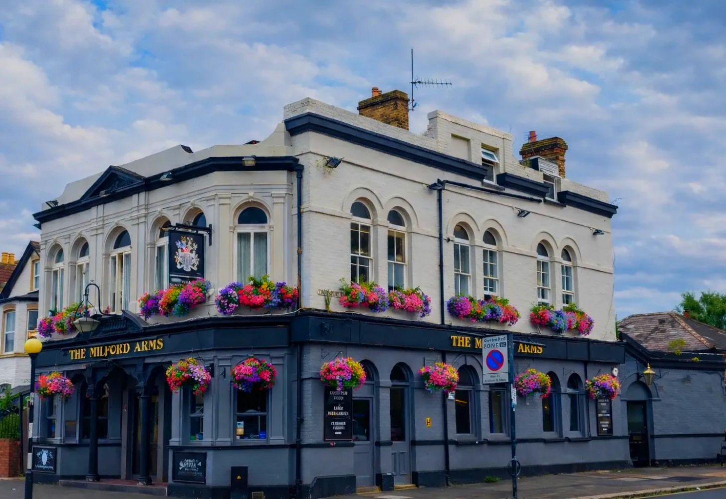 Traditional British pub decorated with colorful flowers.