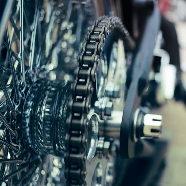Close-up of a bicycle or motorcycle chain and sprocket.