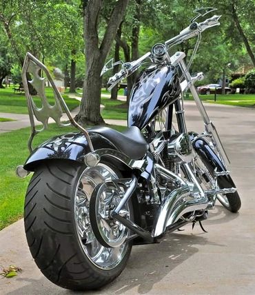 Custom black and chrome chopper motorcycle with wide rear tire and unique handlebars.