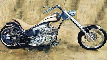 Custom black and beige chopper motorcycle with chrome accents.