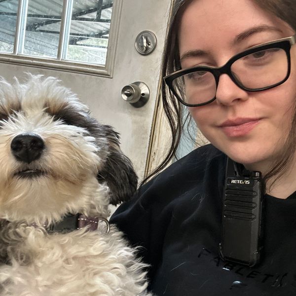 Close-up of a woman with glasses and a fluffy dog.