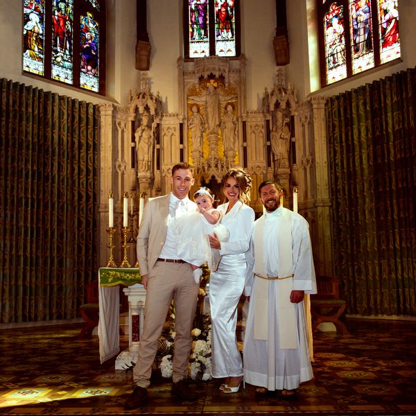 Family posing in church after baptism ceremony.