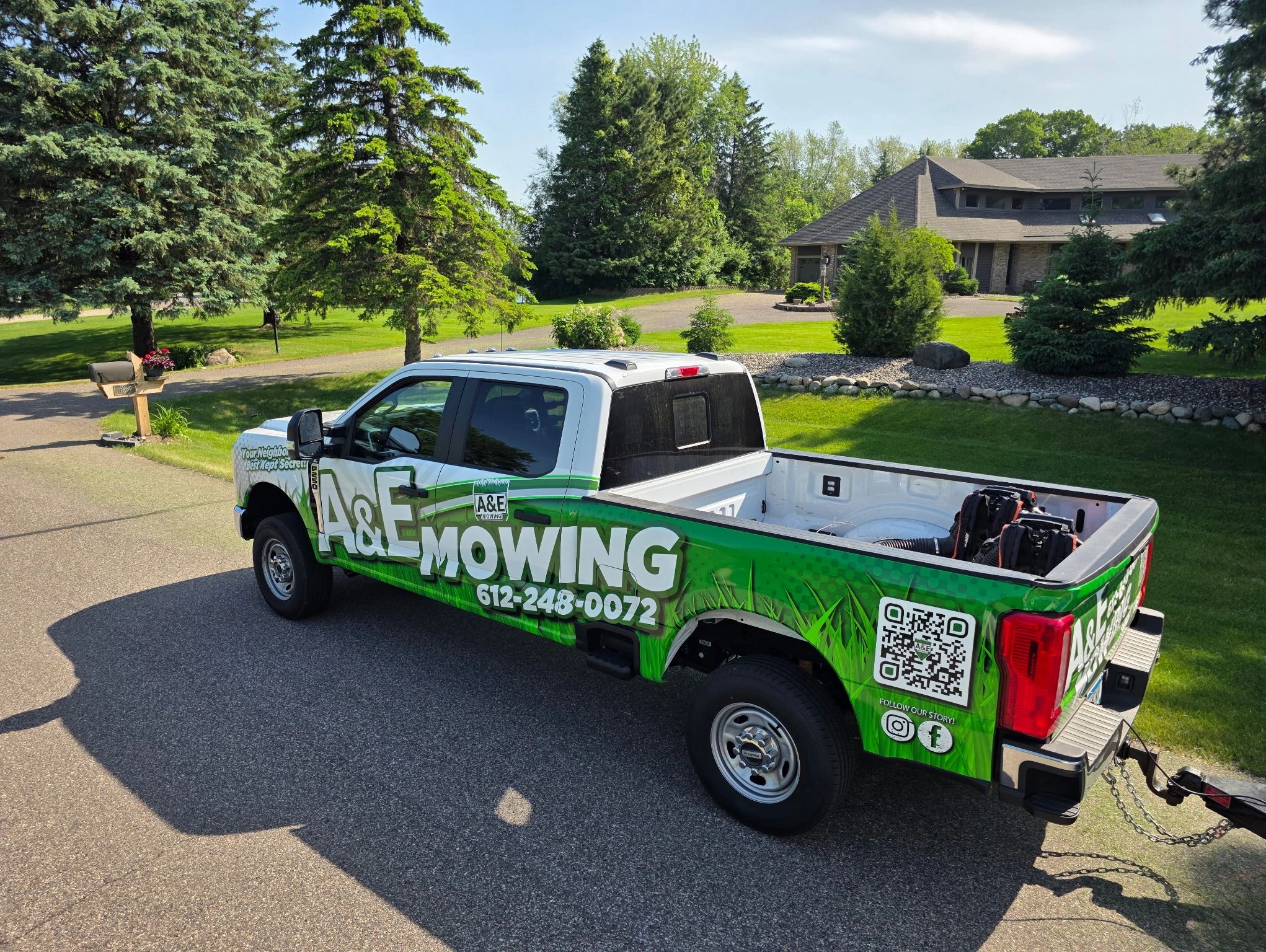 An A&E Mowing crew at a residential property in White Bear Lake completing a lawn mowing service