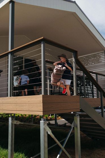 Family enjoying the private deck of a river view cabin at Bridgewater Caravan Park