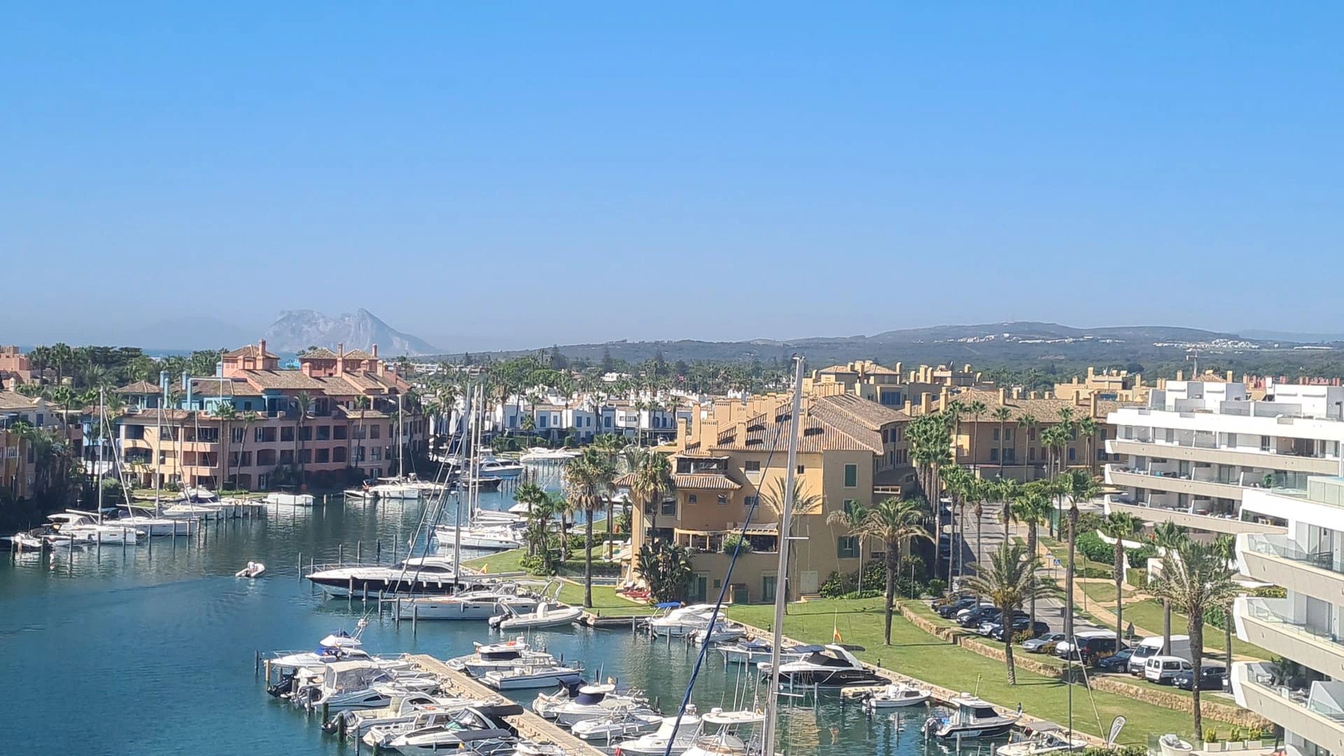 A vibrant marina scene with numerous boats docked, surrounded by colorful buildings