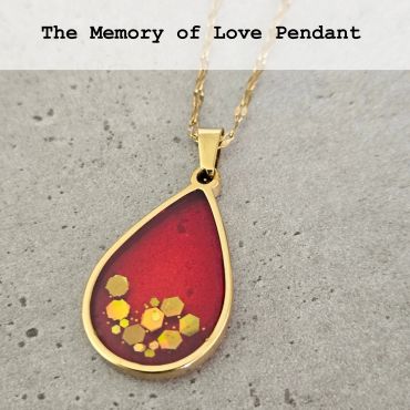 Gold teardrop pendant with red background and hexagonal decorations.
