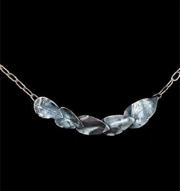 Silver necklace with leaf-shaped pendants on a delicate chain.