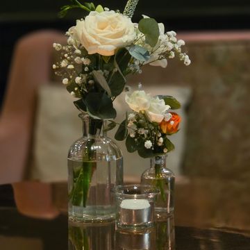 Small floral wedding centrepiece with bud vases and a tea light candle for decoration hire 