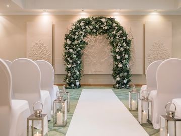 Flower and foliage arch creating an elegant ceremony backdrop for wedding venue styling in Berkshire
