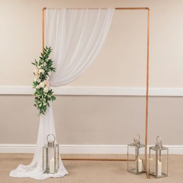 Dressed copper archway creating an elegant statement feature for wedding venue styling