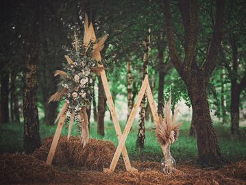 Dressed triangle backdrop creating a stylish focal point for wedding venue styling