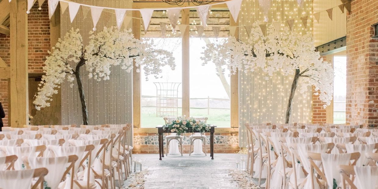 Wedding ceremony styling at Rackleys Barn in the Chiltern Hills with canopy blossom trees and chair 
