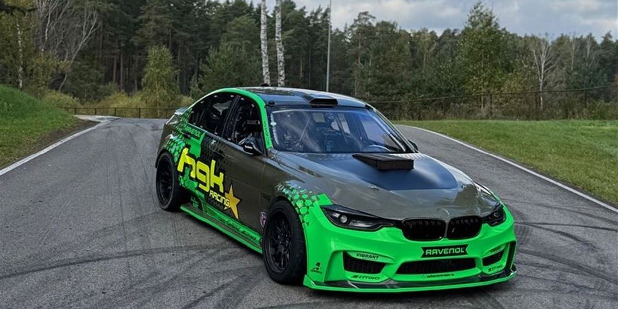 Green and gray racing car on a track.