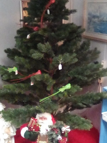 Christmas tree decorated with birds and Santa figurines underneath.
