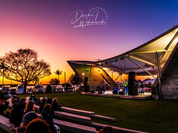 Evening concert at an open-air amphitheater by the water.