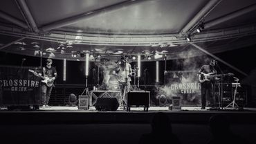 Black and white photo of a band named Crossfire Creek performing on stage.