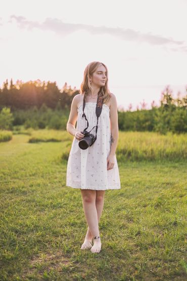 Photographer standing in a field at sunset