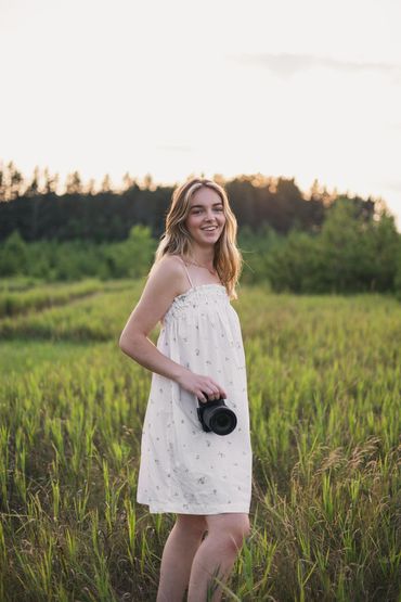 Girl smiling in a field at golden hour