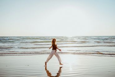 Girl running on the beach during sunset