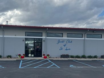Exterior view of Yacht Club of St. Louis building under a cloudy sky.