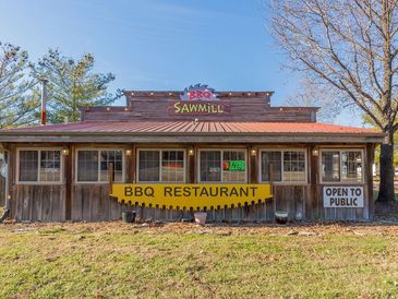 Rustic BBQ Sawmill restaurant open to the public on a sunny day.
