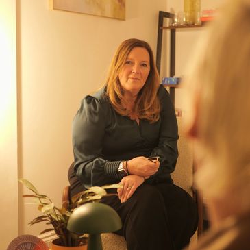 Woman attentively listening during a conversation in a cozy room.