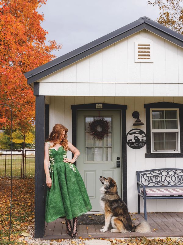 Amanda standing at the therapy cottage with the blind farm dog named Ray Charles