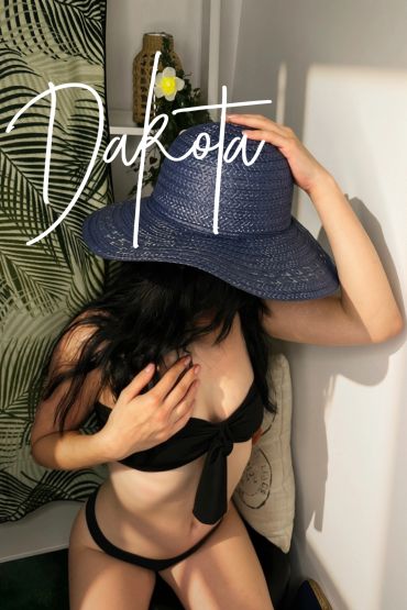 Woman in black bikini and large hat.
