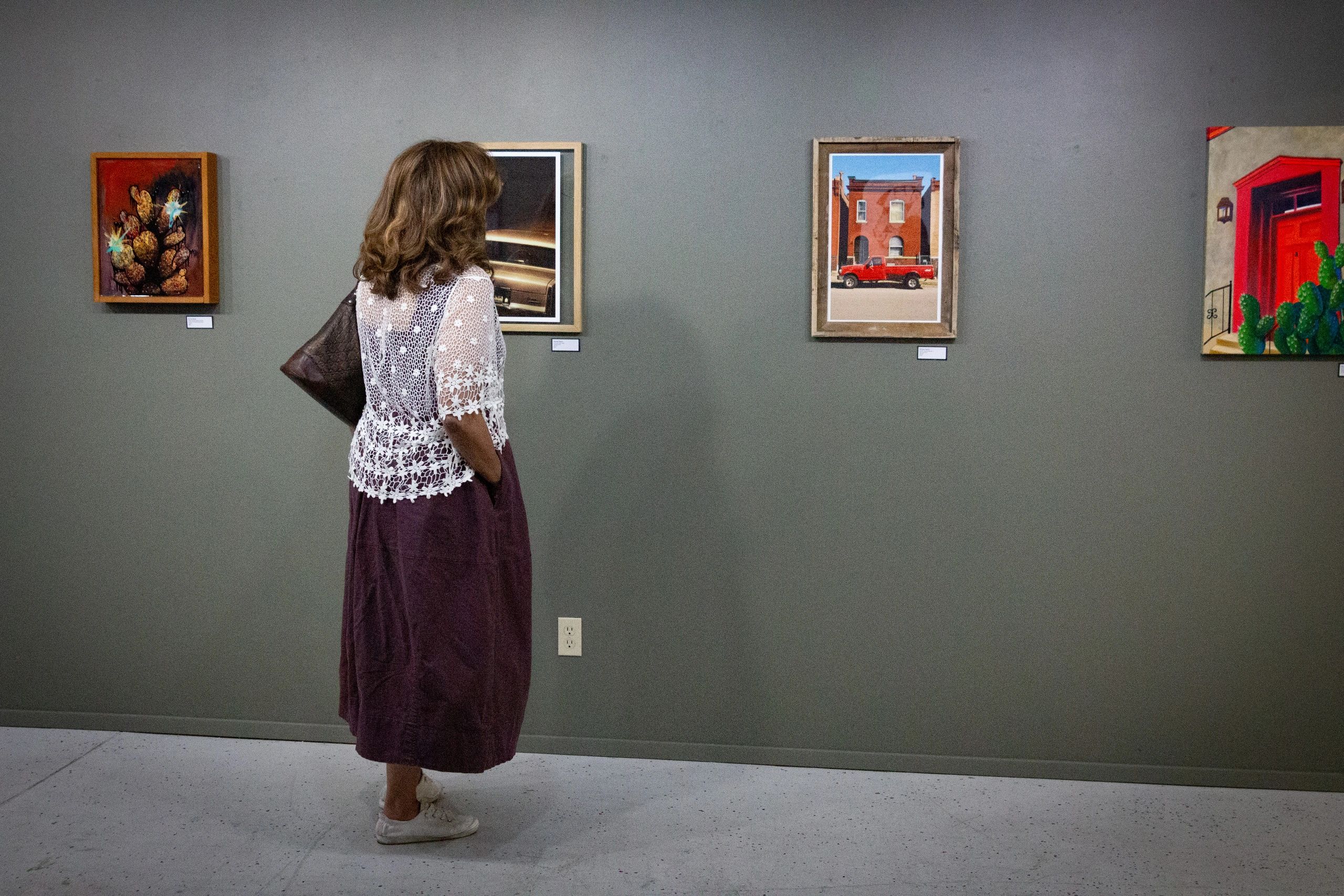 Woman admiring artwork in gallery.