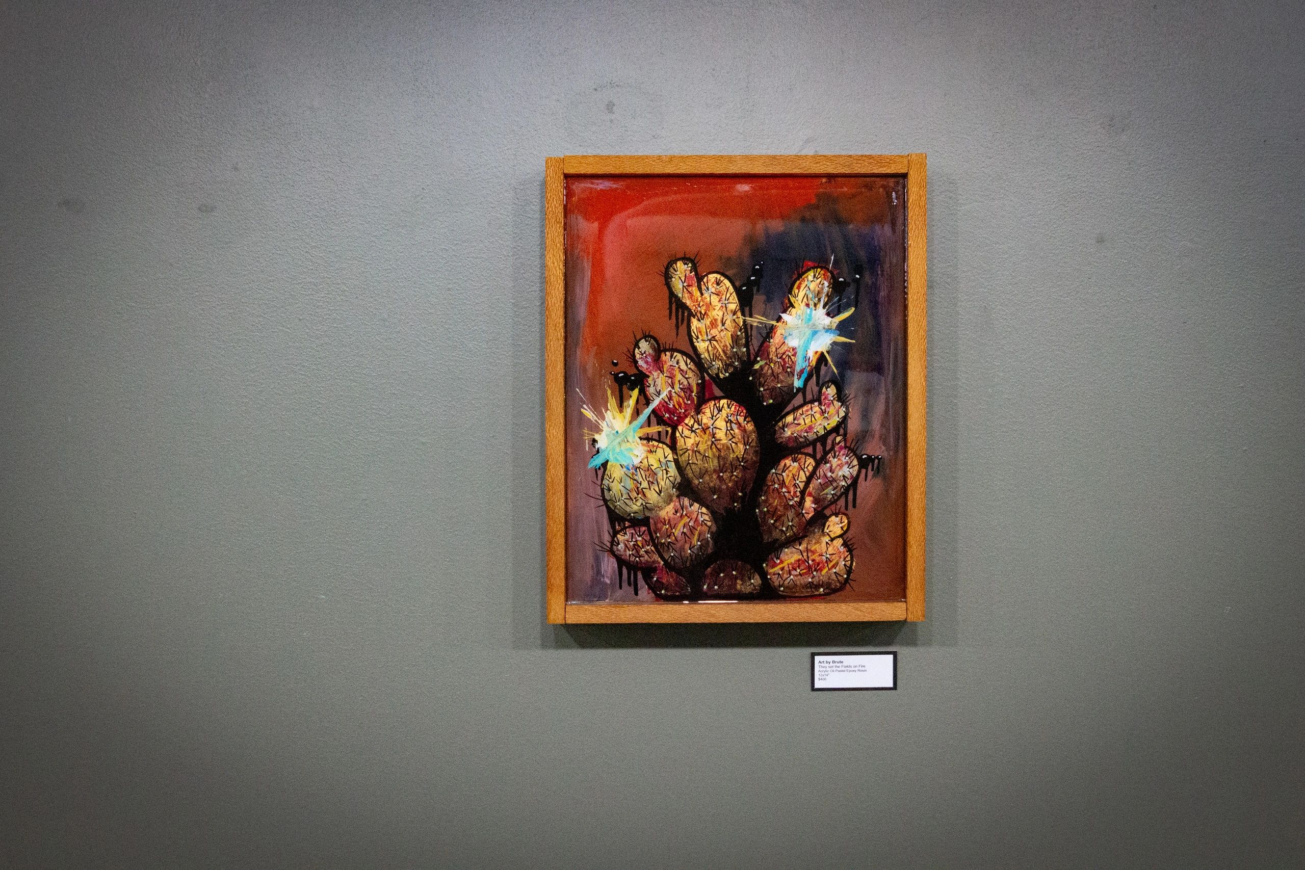 Abstract cactus painting in a wooden frame.