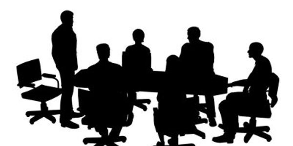Silhouettes of six people in a meeting around a table.