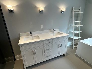 Modern bathroom with a double sink vanity and sleek lighting fixtures.