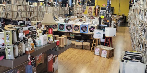 Interior of a vintage record store with vinyls, guitars, and music memorabilia.