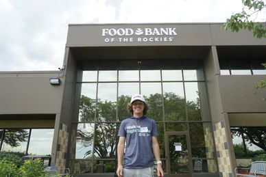 A young person standing outside the Food Bank of the Rockies building.