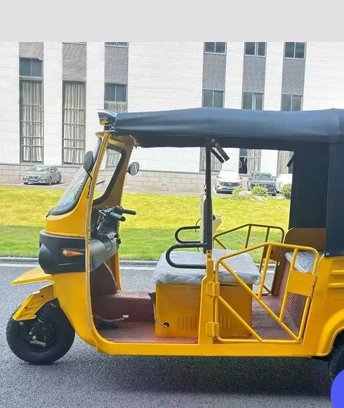 Yellow auto rickshaw parked on the street.
