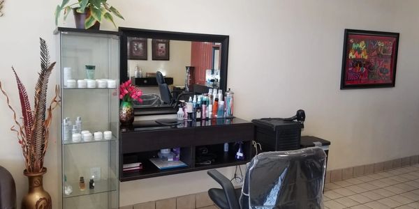 Hair salon workstation with mirror and products.