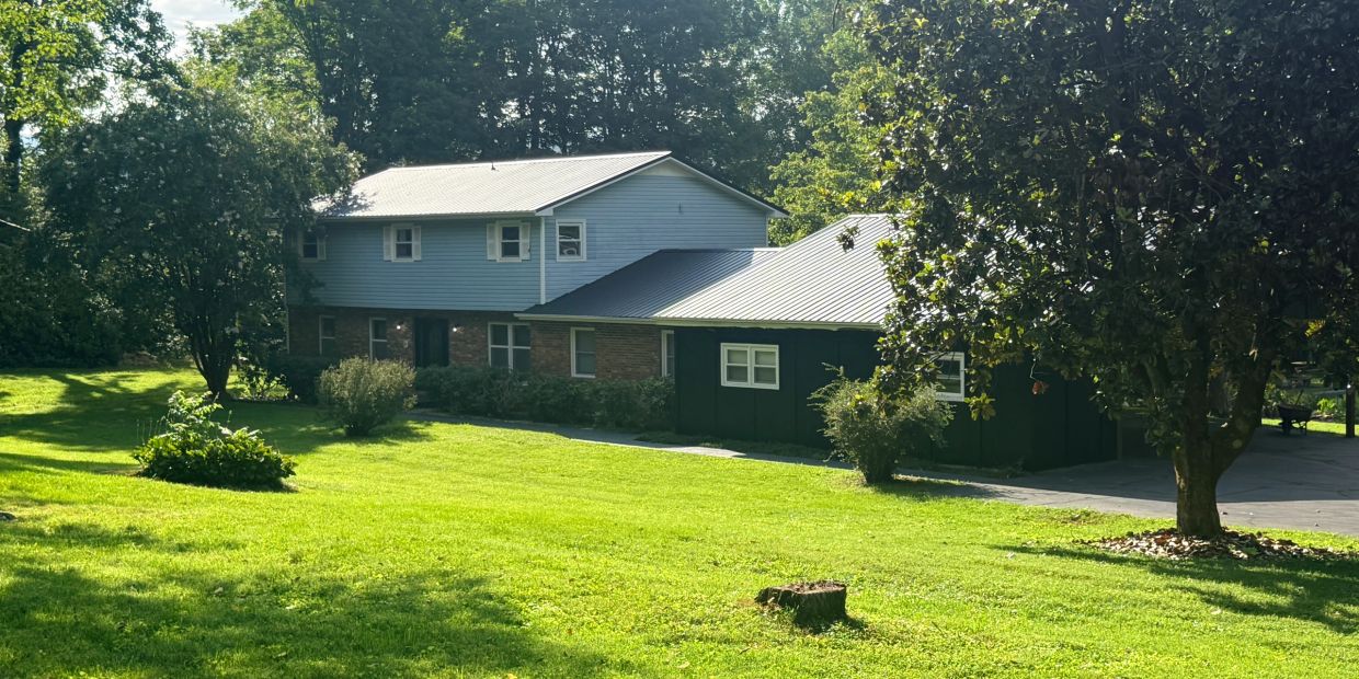 A house surrounded by trees and green lawn.