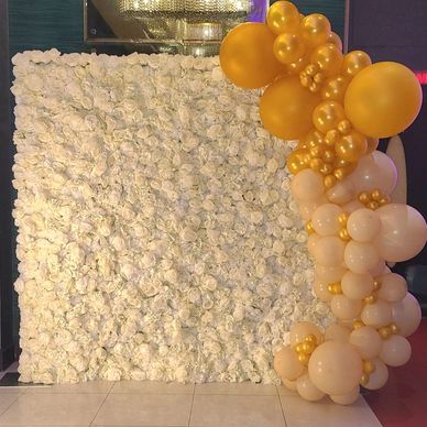White floral wall with gold and cream balloon decoration.