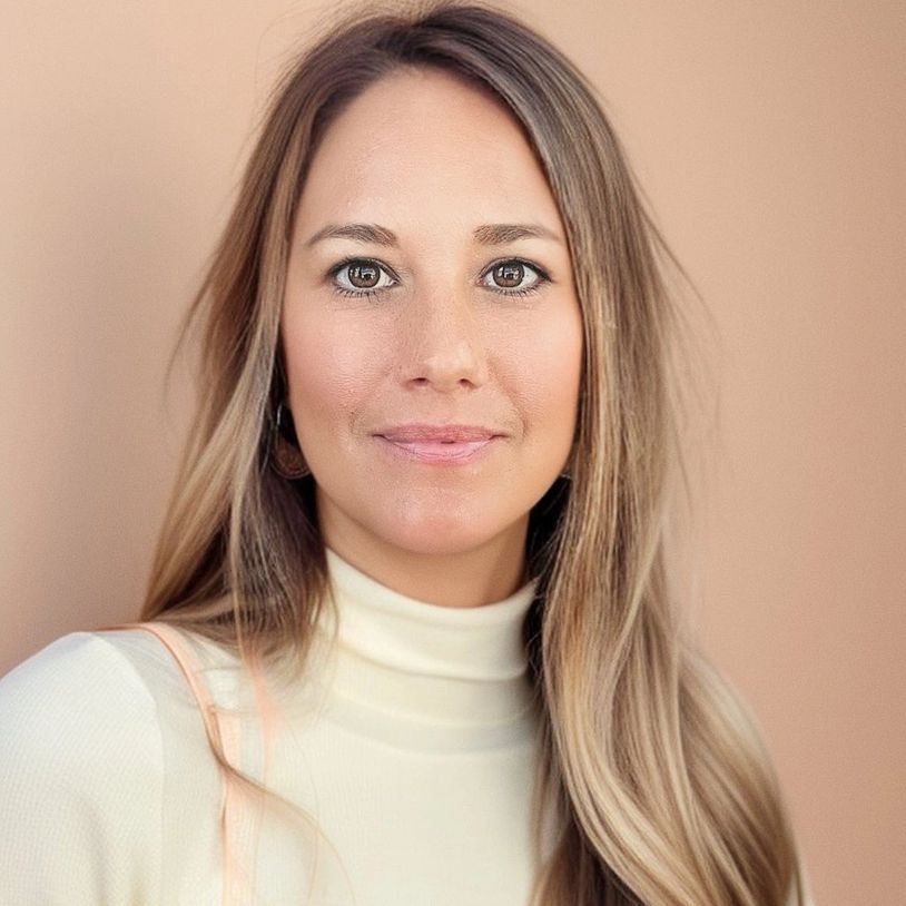 Portrait of a woman with long blonde hair looking at the camera.