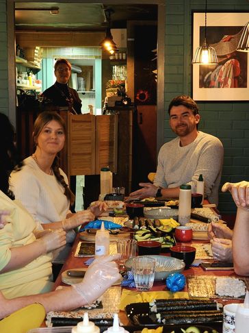 Group enjoying a sushi-making meal together.