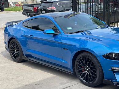 blue mustang with window tinting parked on a driveway
