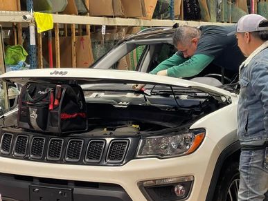 2 persons replacing a windshield on a jeep compass