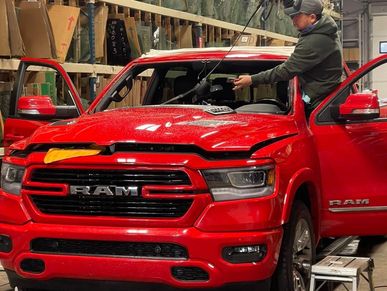 the man replacing a red pickup windshield