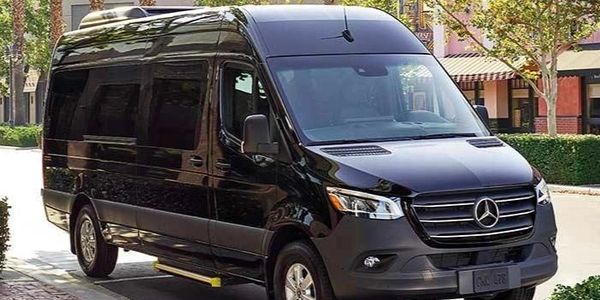 Black Mercedes-Benz Sprinter van parked on a city street.