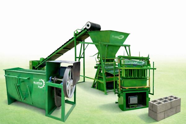 Green concrete block making machine with conveyor and finished blocks.