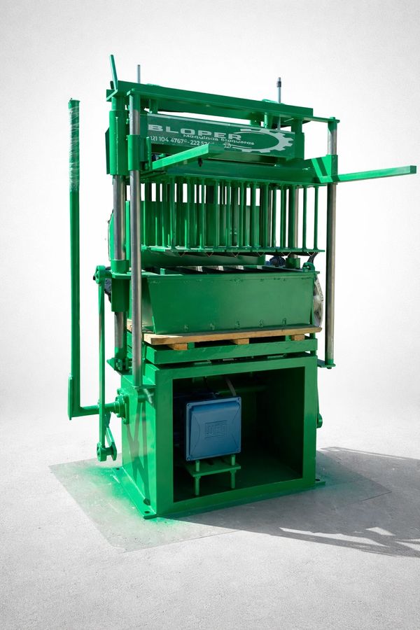 Green industrial machine with metallic components and a blue control box.