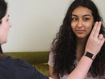 Woman doing a vision test on another woman.