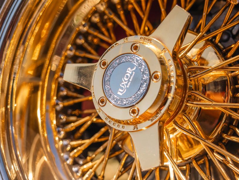 Close-up of a golden Luxor wire wheel rim.