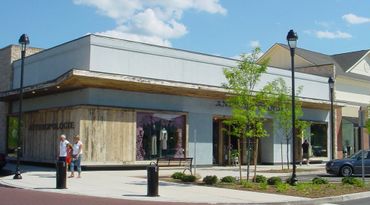 Clothing store on a sunny day with customers outside.