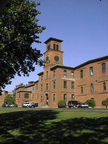Historic brick building with a clock tower under a clear blue sky.